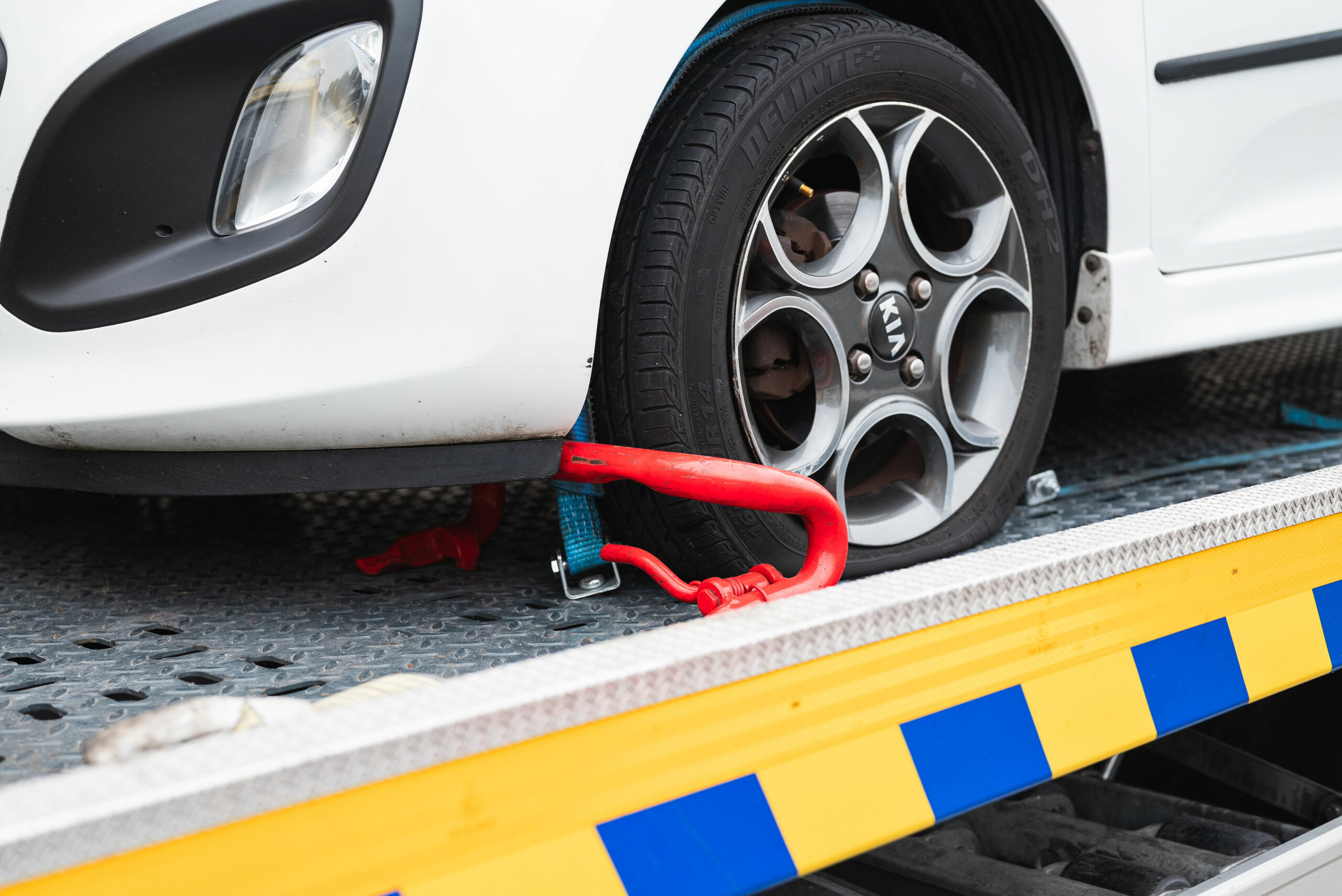 Voorwiel gezekerd op afsleepwagen