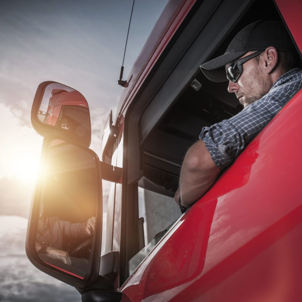 Red Semi Truck. Caucasian Truck Driver Preparing For the Next Destination.